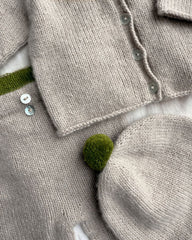 Detaljer fra beige Cleo Baby Set med grøn pompom
