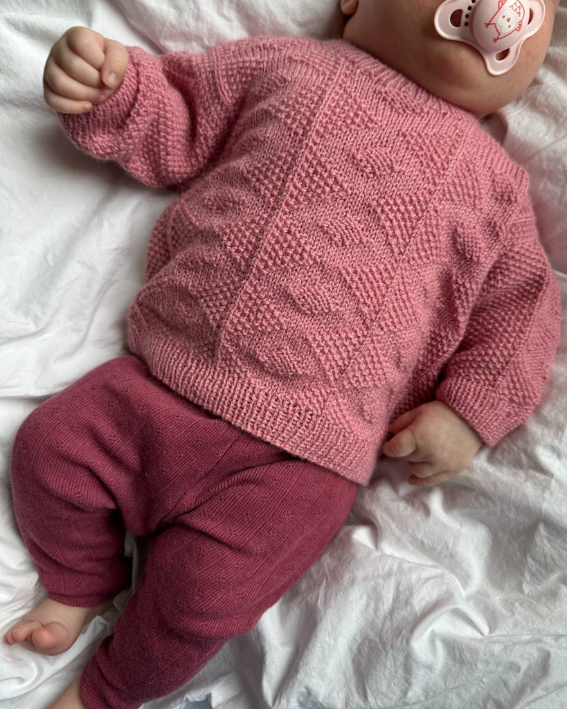 Baby iført lyserød Esther Sweater Baby