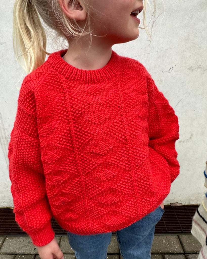 Barn iført rød Esther Sweater Junior
