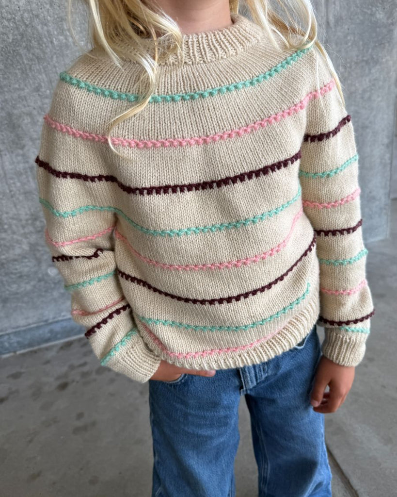 Barn iført Festival Sweater med striber i turkis, lyserød og bordeaux
