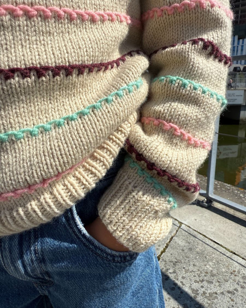 Closeup af Festival Sweater med striber i turkis, lyserød og bordeaux