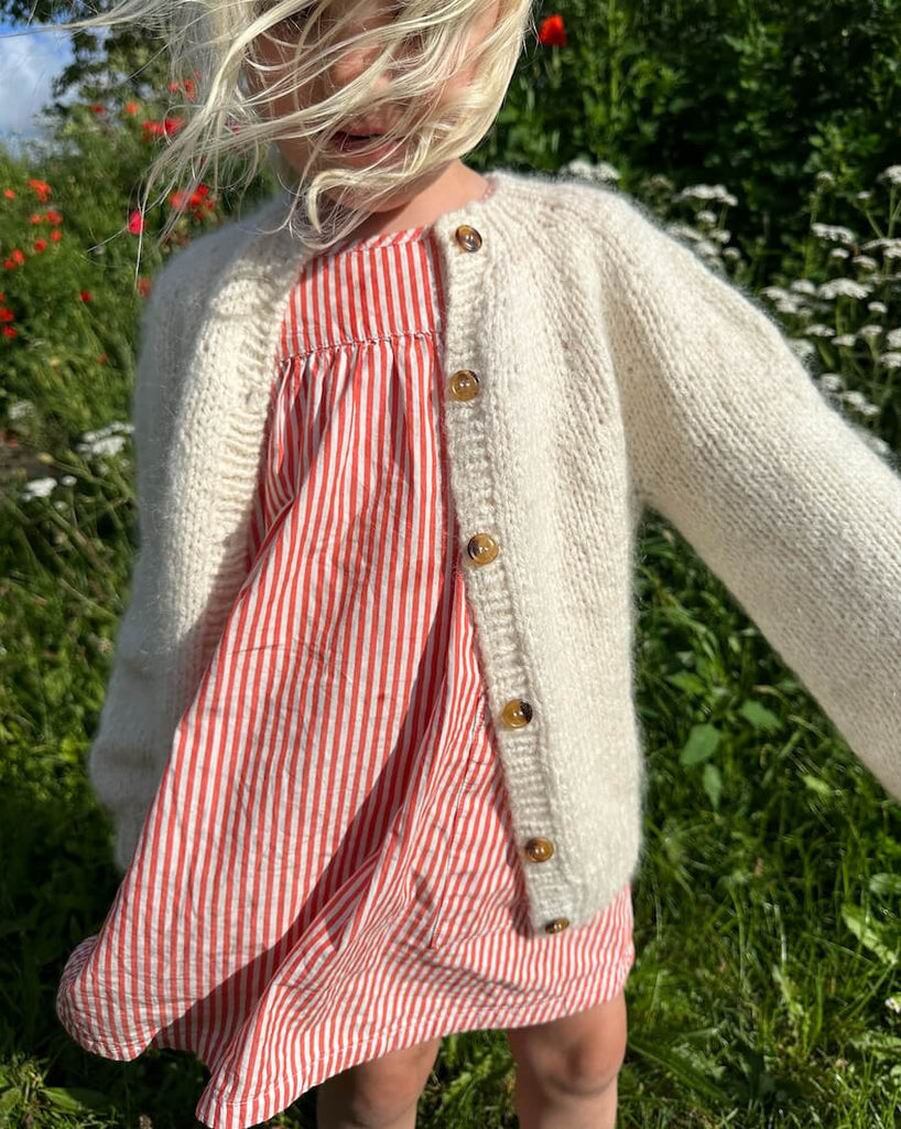 Barn iført hvid Novice Cardigan Mini – Chunky Edition