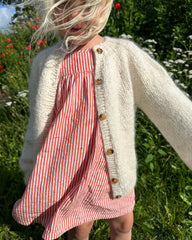 Barn iført hvid Novice Cardigan Mini – Chunky Edition