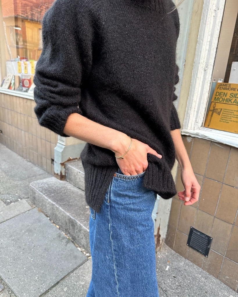 Kvinde iført sort October Sweater