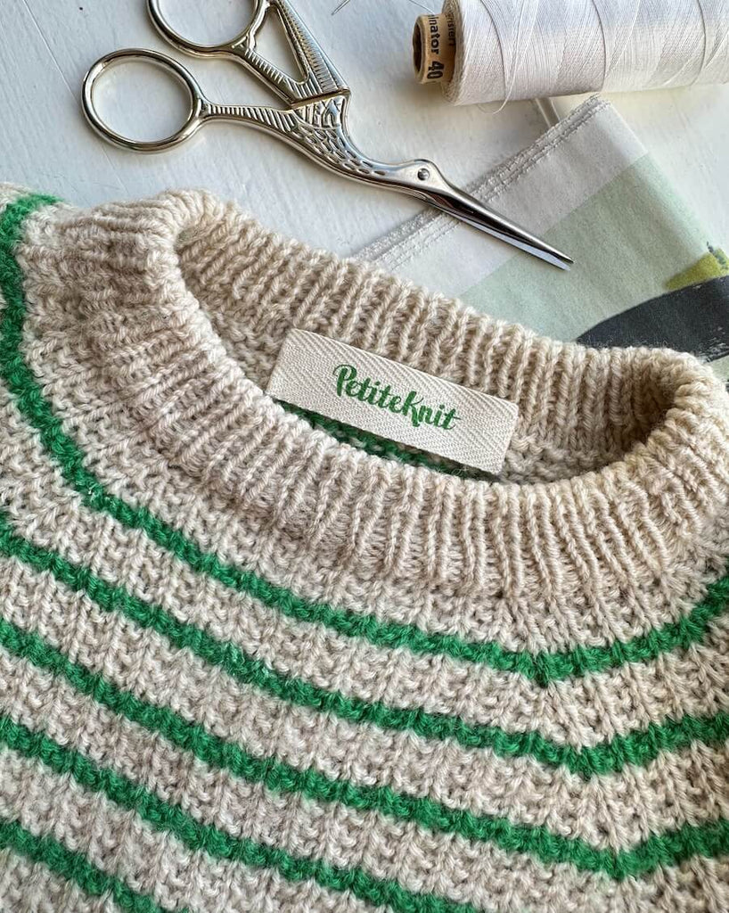 Label med petiteknit logo i statement green på friday sweater baby