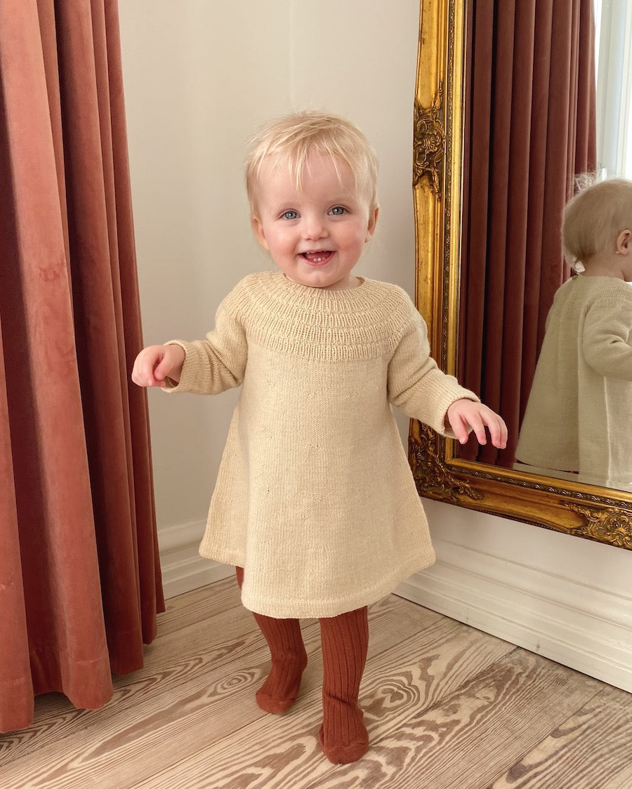 Barn iført beige Ankers Kjole