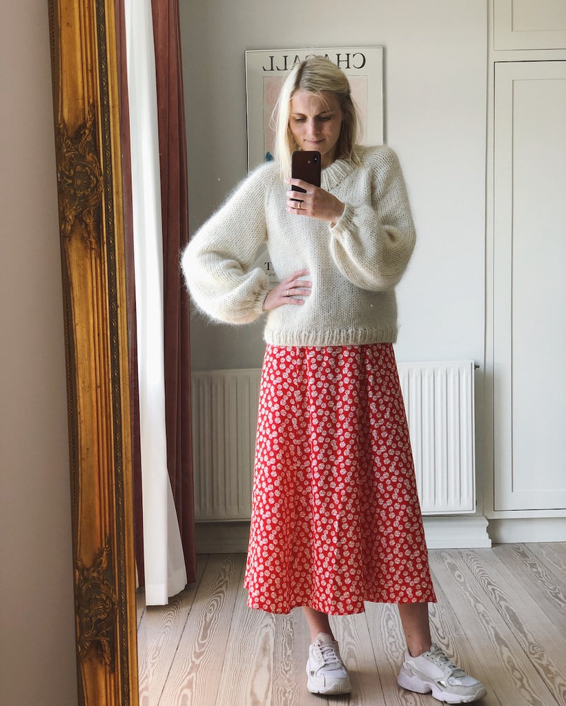 Kvinde iført hvid Holiday Sweater 