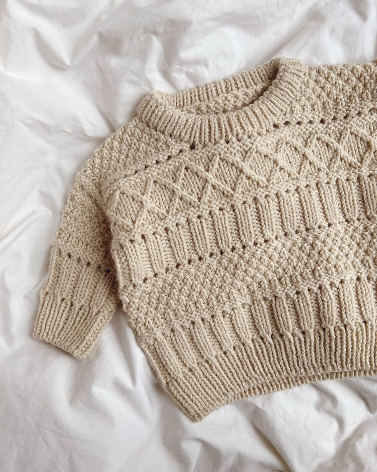 Baby iført grønlig Ingrid Sweater Baby 