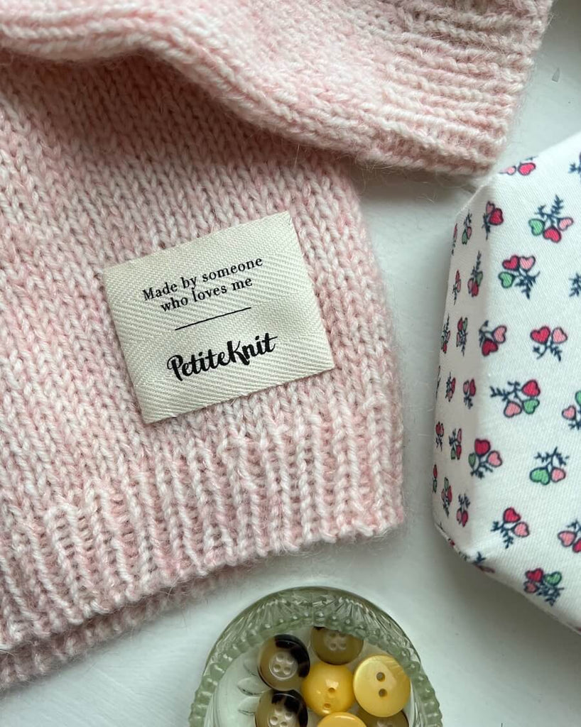 Made by someone who loves me label i bunden af lyserød striktrøje