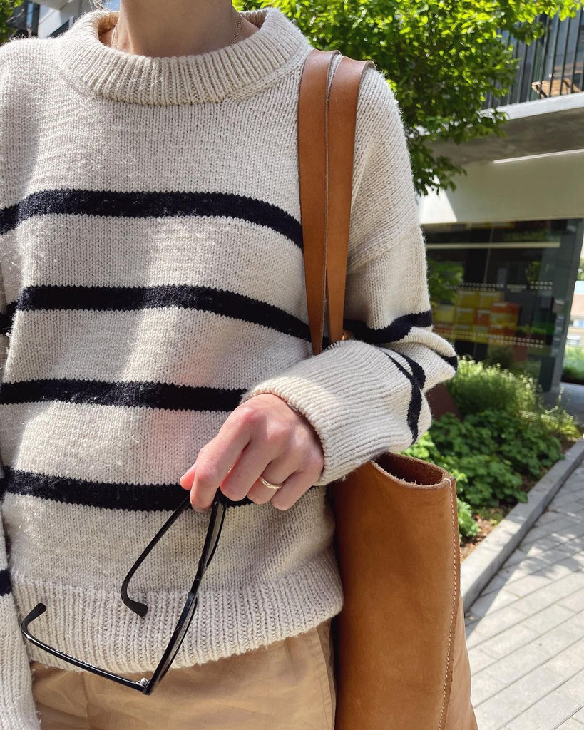 Kvinde iført hvid og blå Marseille Sweater