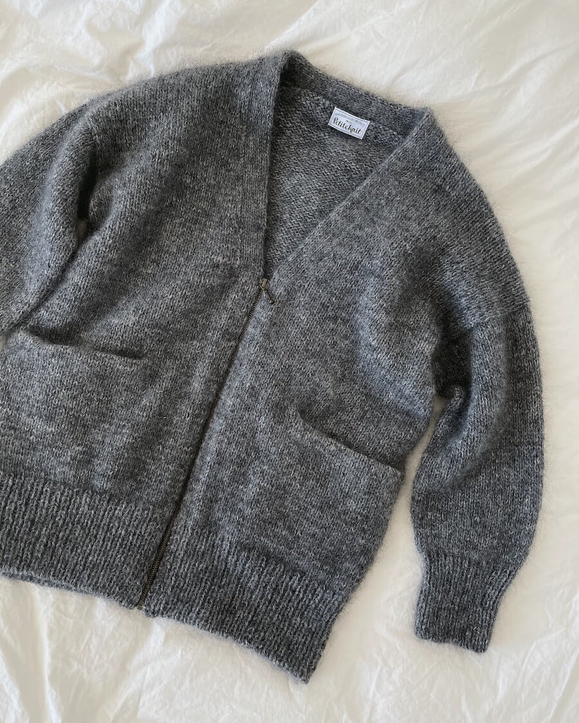 Grå Zipper Jacket liggende på dyne